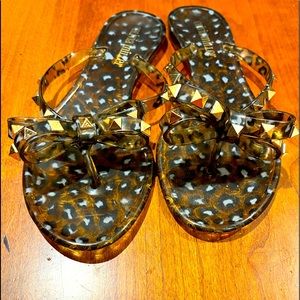 Woman’s brown and black animal design sandals with gold embellishments